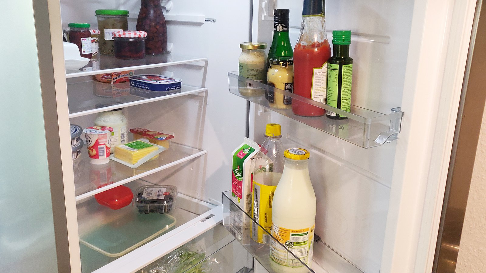 Blick in einen halbvollen Kühlschrank mit verschiedenen Lebensmitteln