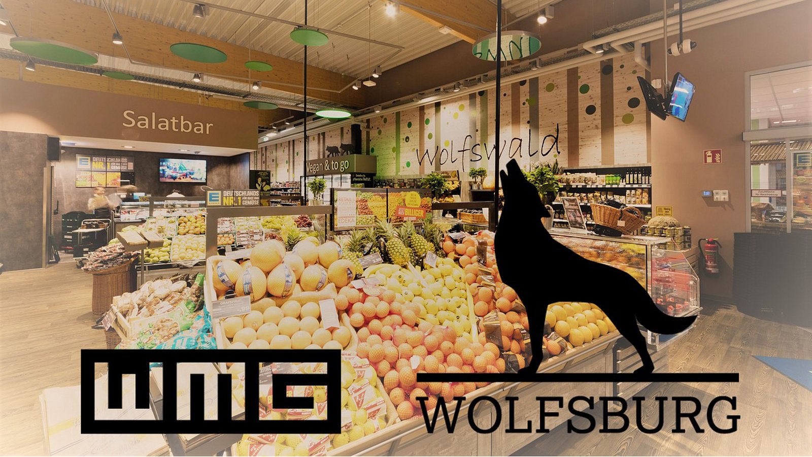 Logo WMG Wolfsburg, im Hintergrund Aufnahme der Obst- und Gemüseabteilung eines Supermarkts