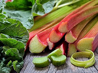 Mehrere Standen Rharbarber liegen auf einem Holzbrett. 