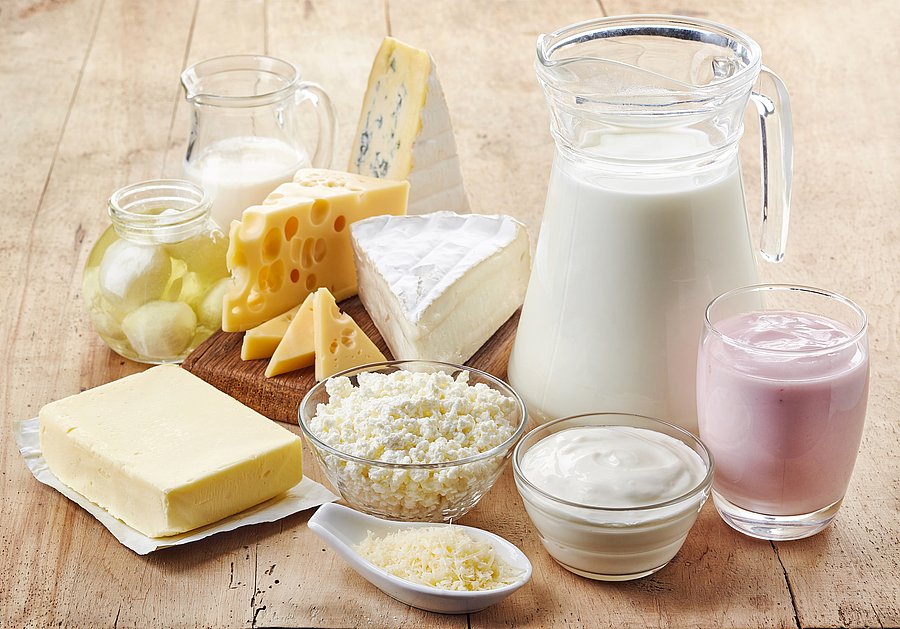 Verschiedene Milchprodukte auf einem Tisch. Käse, Milch, Butter sowie Joghurt.