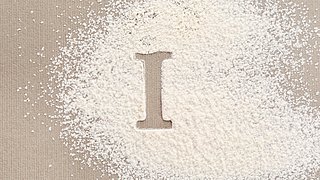 Ein I, das in einem Haufen Mehl ausgespart ist
