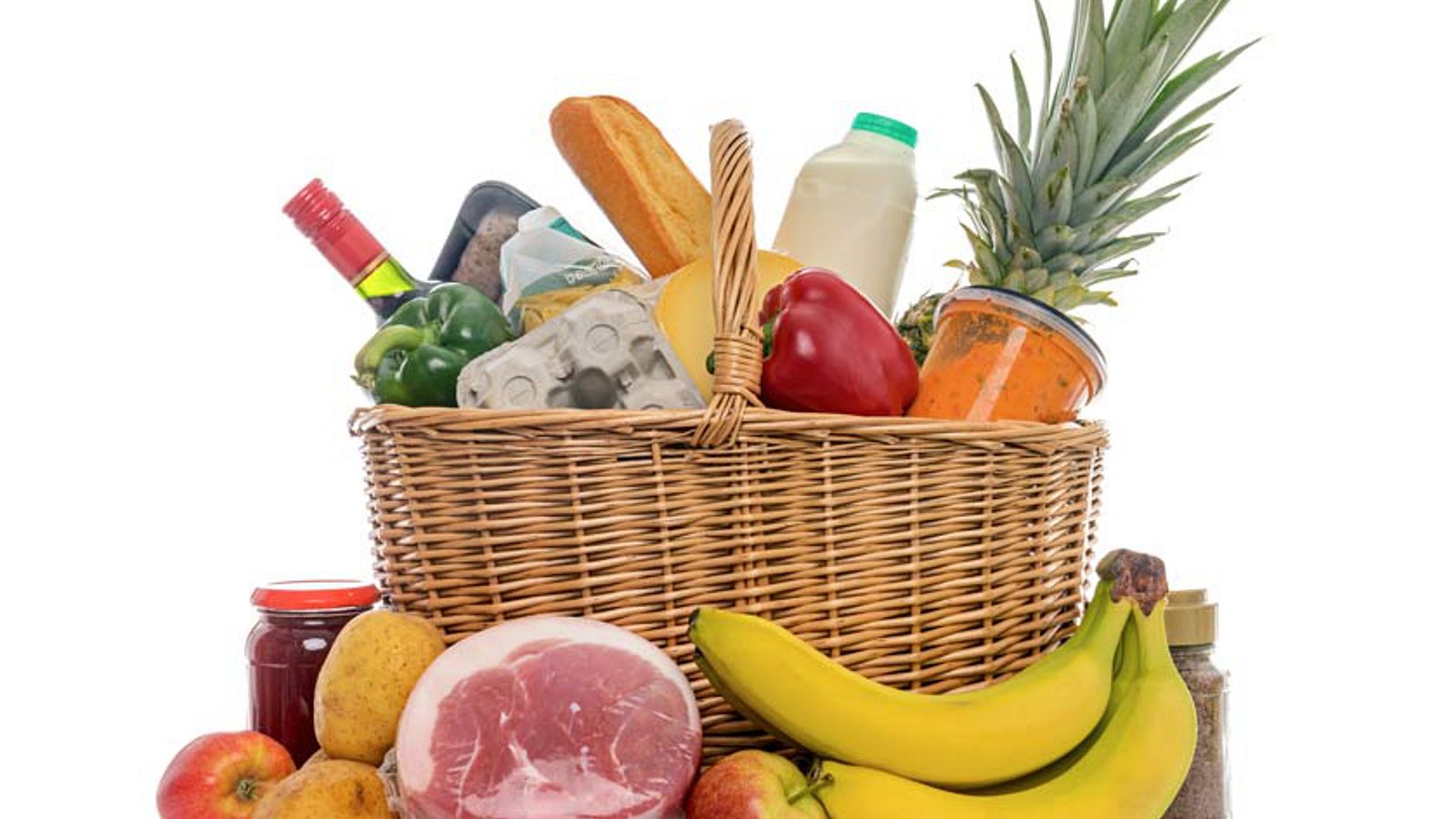 Einkaufskorb voller Sachen wie Wein, Milch, Bananen, Eiern, Schinken und Kartoffeln