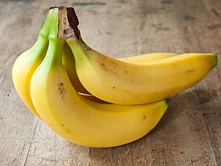 Drei zusammenhängende gelbe Bananen.