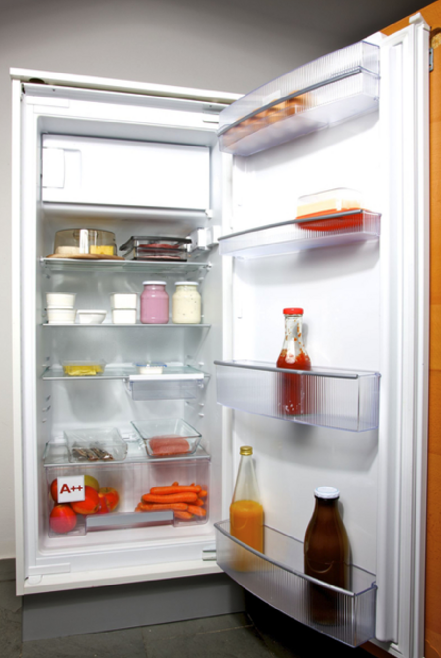 Offener, mit Lebensmitteln gefüllter Kühlschrank.