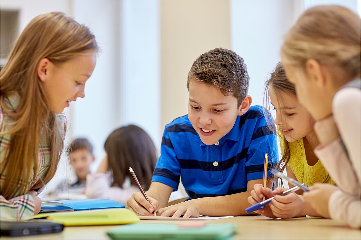 Kinder, die an Schulaufgaben arbeiten und lachen