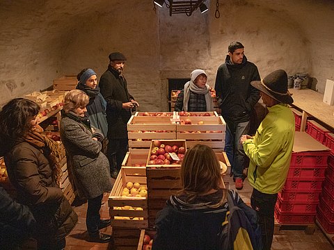 Besucher werden durch ein Lebensmittel-Lager geführt.