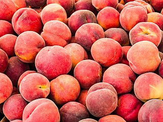 Viele Pfirsiche liegen nebeneinander und übereinander.