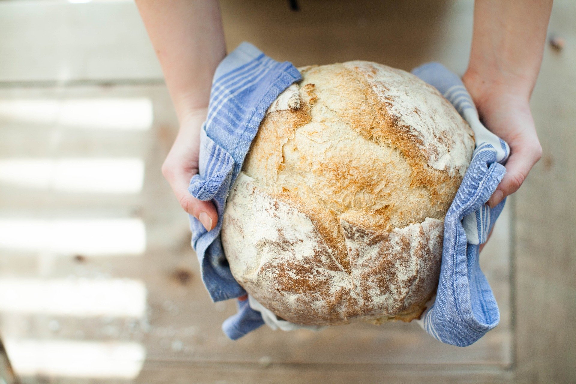 Zwei Hände halten einen Laib Brot in der Hand