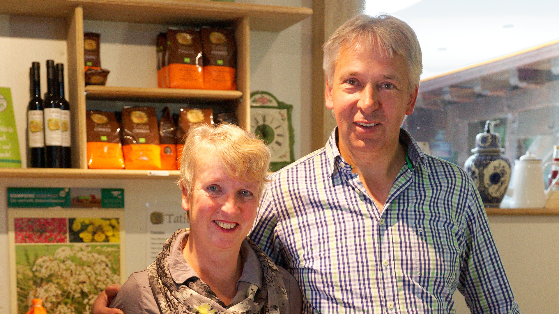 das Bild zeigt ein älteres Ehepaar in ihrer Küche. Sie lächeln in die Kamera.